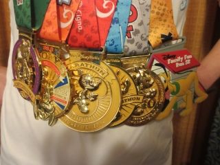 My medals from the Walt Disney World Marathon Weekend - (r - l) - Disney Family Fun Run 5k, Disney World Inaugural 10K, Disney World Half marathon, Disney World Marathon, Goofy Challenge, Inaugural Dopey Challenge